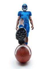 American football player in blue uniform and helmet standing with one foot on a football viewed from an uncommon perspective, creating an impressive effect in the foreground.
