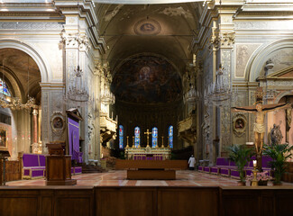 Baroque church interior with frescoed apse, chandeliers, pews, and stained glass windows in Ferrara...