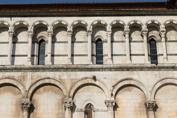 Blind arches and clerestory windows of San Michele in Foro, Lucca, Italy, with alternating marble...