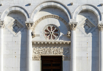 Main portal of San Michele in Foro, Lucca, Italy, with rose window, sculpted archivolt, column...