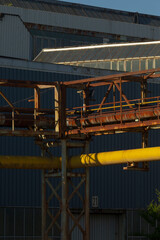 There is a large building that has a significant number of pipes prominently located in front of it, possibly for various functions or utilities