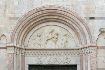 Relief of Virgin Mary with Child and two angels in the tympanum of a Romanesque portal, San Martino...