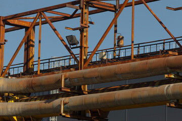 There is an extensive bridge that has numerous pipes running over it, showcasing various...