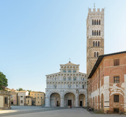 San Martino Cathedral and bell tower in Lucca, Italy, with Romanesque facade featuring sculpted...