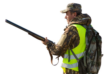 Hunter man in camouflage with a gun during the hunt in search of wild birds or game.