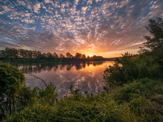 Beautiful Sunset Over The River with Cloud Reflections
