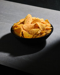 Big bowl of crispy wavy potato chips. Snacks, beer appetizer.