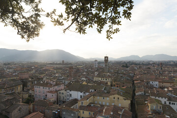 View from Torre Guinigi over rooftops of Lucca, Tuscany, Italy, showing Torre delle Ore and bell...