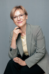 Portrait of happy woman. Confident, successful mature woman on light gray background. Looking at...