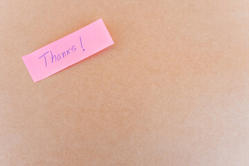 Thank you note that says thank you, handwritten with blue pen on a solid background