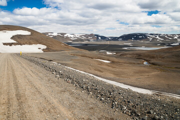 mountain road in an empty landscape in iceland at a sunny day