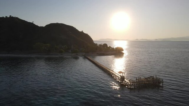 Aerial landscape view of Kanawa Island beach with long bridge dock surrounded by turquoise ocean.