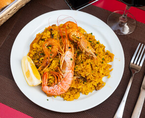Seafood paella, prepared according to Italian recipe. dish consists of mussels, shrimp, fish fillet and rice. Hearty dish served in coastal taverns.