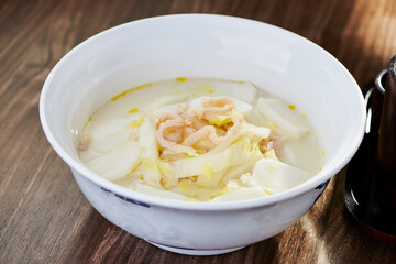 Shredded Pork and Rice Cake Soup with Napa Cabbage served in bowl side view of Authentic Chinese...