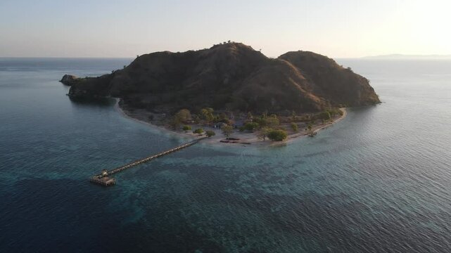 Aerial landscape view of Kanawa Island beach with long bridge dock surrounded by turquoise ocean.