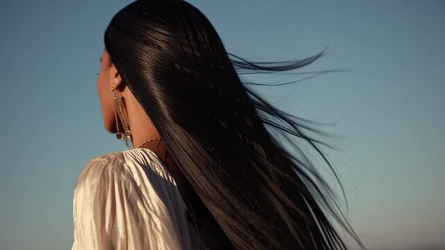 Black woman with long straight hair flowing in the wind, concept of beauty and hair care