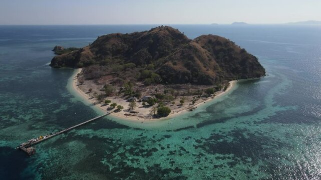 Aerial landscape view of Kanawa Island beach with long bridge dock surrounded by turquoise ocean.
