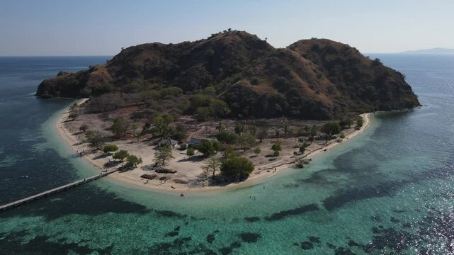 Aerial landscape view of Kanawa Island beach with long bridge dock surrounded by turquoise ocean.