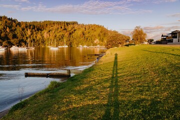 A photographer captures the golden hour at a harbor in Whangamata, Coromandel Peninsula, New...