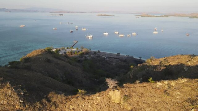 Aerial landscape view of Kanawa Island beach with long bridge dock surrounded by turquoise ocean.