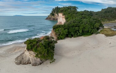 Coastal scene in Whiritoa, Coromandel Peninsula, New Zealand featuring a sandy beach meeting the...