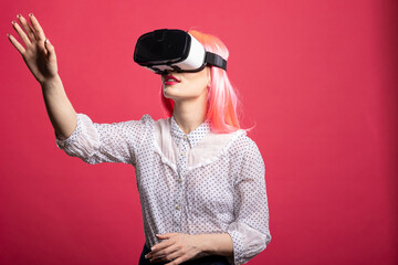 Caucasian female model using VR headset reaching forward with her hand, engaging with futuristic...