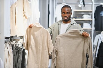 Stylish man choosing clothes in fashion store