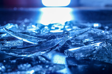 Broken Glass Shards on Dark Surface with Cold Blue Lighting