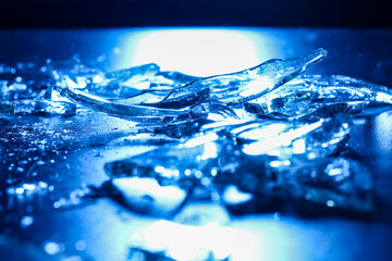 Broken Glass Shards on Dark Surface with Cold Blue Lighting