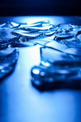 Broken Glass Shards on Dark Surface with Cold Blue Lighting