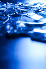 Broken Glass Shards on Dark Surface with Cold Blue Lighting