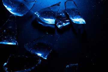 Broken Glass Shards on Dark Surface with Cold Blue Lighting