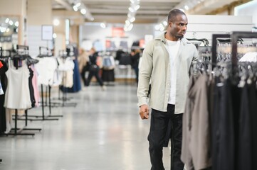 Stylish man choosing clothes in fashion store