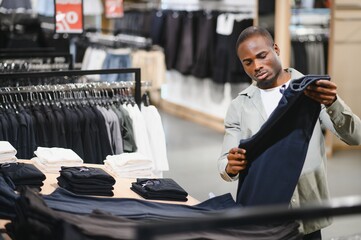 Customer choosing pants in clothing store