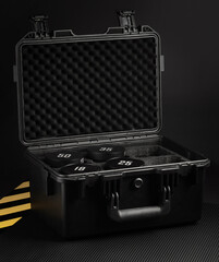 A sturdy black case holds four weight plates marked with varying weights, positioned in a gym...
