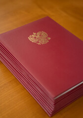 An Elegant Red Bound Volume Displayed with a Golden Emblem on a Beautiful Wooden Table