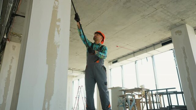 Painter priming walls in a building under construction