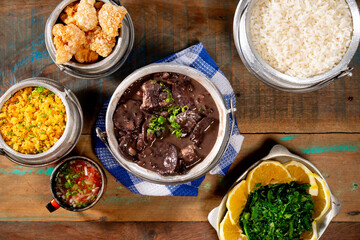 Typical Brazilian dish feijoada based on black beans and pork with crakloing, rice and orange.
