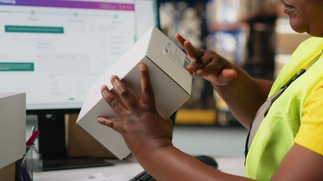 African american staff works on packages labeling for express delivery, ensuring accurate package tracking with a professional software. Worker processing orders in stock room. Camera B.