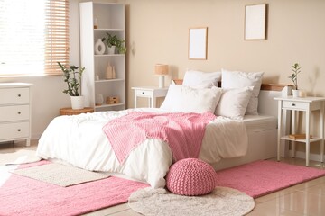Interior of light bedroom with cozy bed, pouf and bedside tables