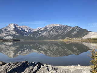 beautiful landscape image of mountains surrounding a lake, with a blue sky
