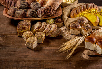 assortment of baked bread on wooden table background.