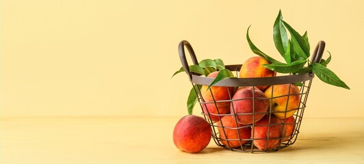 Basket of fresh peaches on beige background with space for text