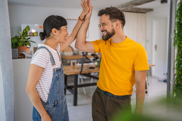 Portrait of woman and man raise hands and celebrate success together