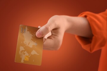 Hand with credit card on red background