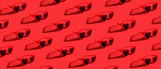 Stylish female sunglasses on red background
