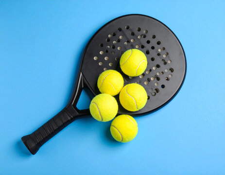 Overhead View of Padel Racket and Tennis Balls on Blue Background