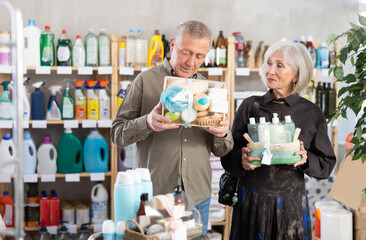 Senior spouses buyer select and studies label, read composition of shower cosmetic set present....