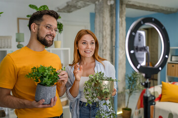 couple v-loggers hold plants and record video for social network