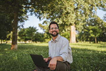 businessman sit on grass in nature and use laptop for work or leisure